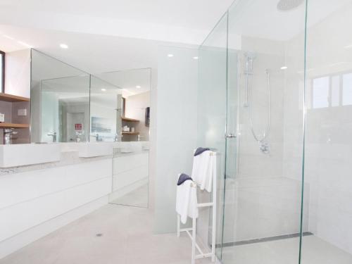 a bathroom with a shower and a glass door at Parkyn Place 7 in Mooloolaba