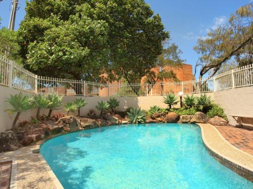 a swimming pool in a yard with a fence at Parkyn Place 7 in Mooloolaba