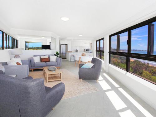 a living room with couches and chairs and windows at Parkyn Place 7 in Mooloolaba