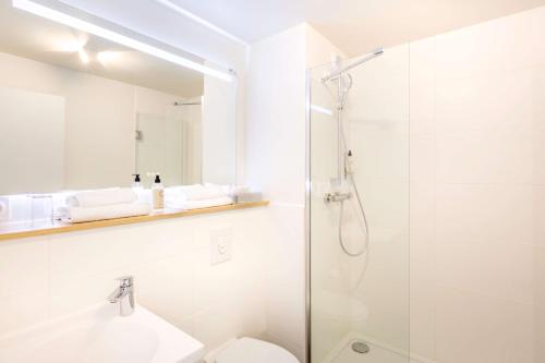 a bathroom with a shower, sink, and toilet at Best Western Armor Park Dinan in Dinan