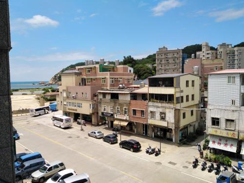 a city with cars parked on a street with buildings at 星海芝家民宿Samuel's Home in Nangan