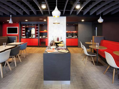 a restaurant with tables and chairs and red cabinets at ibis Brighton City Centre - Station in Brighton & Hove