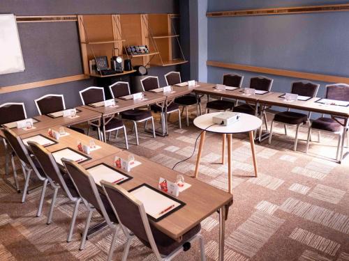 a room with tables and chairs in a classroom at ibis Paris Gennevilliers in Gennevilliers