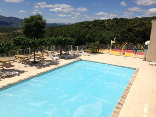 a large blue swimming pool with a playground at Domaine Plein Sud in Bruzac