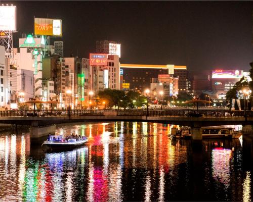 a boat on a river in a city at night at THE HOTELS HAKATA KASANE Bayside in Fukuoka