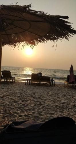 twee banken op een strand met de oceaan bij Ocean Glass in Baga