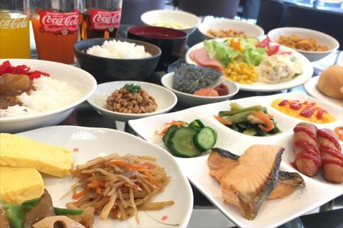 a table full of plates of food with different foods at Green Rich Hotel Hamada Ekimae (Artificial hot spring Futamata Yunohana) in Hamada