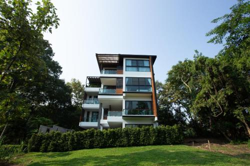 an apartment building with balconies and a yard at Reiz - Private Residence in Chiang Mai