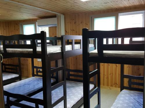 a room with three bunk beds in a cabin at Guest House Manna in Daegu