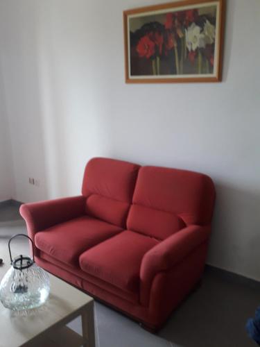a red couch in a living room with a table at Appartement vue sur mer in Toubab Dialaw