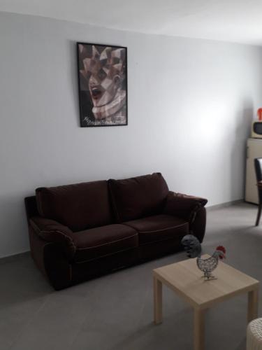 a living room with a brown couch and a table at Appartement vue sur mer in Toubab Dialaw