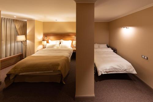 a hotel room with two beds and a window at Daria Suite in Târgu Jiu