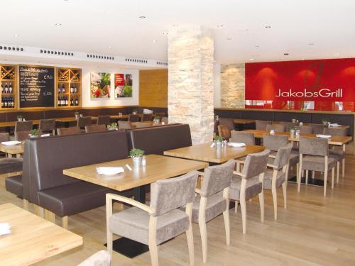 a restaurant with wooden tables and chairs and a bar at Seligweiler Hotel & Restaurant in Ulm