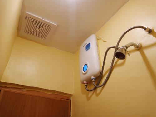 a bathroom with a shower head on the wall at TAGBALAYON Lodging House in Siquijor