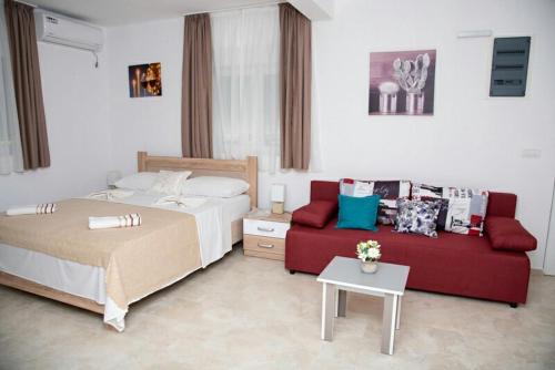 ヴィルパザルにあるApartments Nino Skadar lakeのベッドとソファ付きのホテルルーム