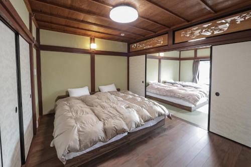 um quarto com 2 camas e um tecto de madeira em Takashima Jinya em Takashima