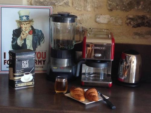 a counter with a coffee maker and croissants and a blender at Johnson's house les pieds dans l'eau in Saint-Aubin-sur-Mer