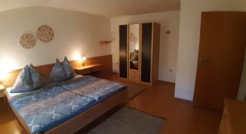 a bedroom with a bed with a blue comforter at Haus Königshofer in Neusiedl am See