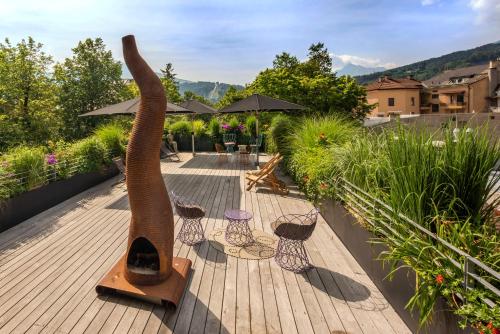 a wooden deck with some chairs and umbrellas at Nala Individuellhotel in Innsbruck