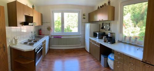 a large kitchen with a refrigerator and a window at Vakantiehuis ibu in Altenau
