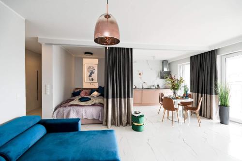 a bedroom with a bed and a table and a kitchen at Apartament MARCELIN GOLD Wes Quality Suite in Poznań