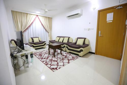 a living room with two couches and a television at Al Rayyan Hotel Apartments Muscat in Seeb