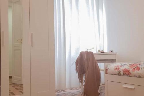 CASACRIZIA في كالياري: غرفة نوم بسرير ونافذة ذات ستائر بيضاء