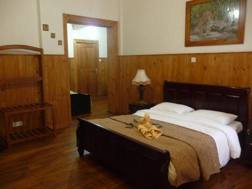 a bedroom with a large bed with a stuffed animal on it at The Trevene Hotel in Nuwara Eliya