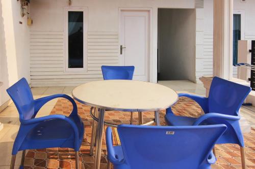 a table with blue chairs and a white table at OYO 1456 Hotel Garuda in Lampung