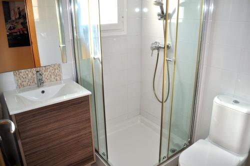 a bathroom with a shower and a sink and a toilet at Brisas A1, 2 dormitorios, playa a 50m, by Bookindenia in Denia