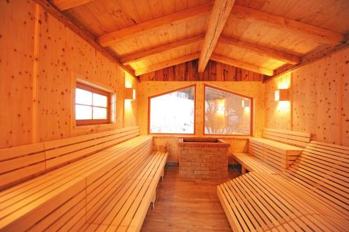 an empty room with benches in a wooden building at Ski in Ski out Hotel Unterellmau inkl Jokercard in Saalbach-Hinterglemm