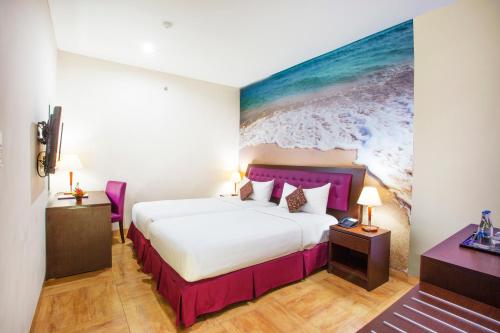 a hotel room with a bed and a painting on the wall at Kuta Central Park Hotel in Kuta