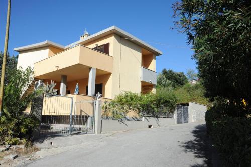 a house with a fence in front of it at Il Roseto in Procchio