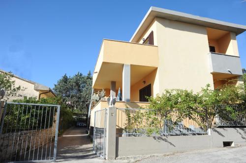 a house with a fence in front of it at Il Roseto in Procchio