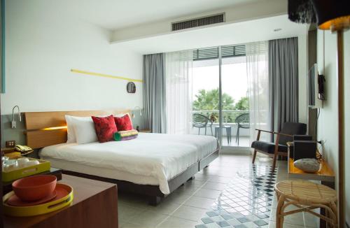 a bedroom with a bed and a living room at Baboona Beachfront Living in Pattaya Central