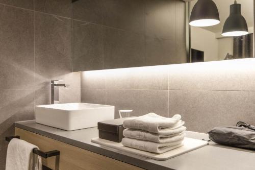 La salle de bains est pourvue d'un lavabo et d'un tas de serviettes. dans l'établissement H hotel Gasan, à Séoul