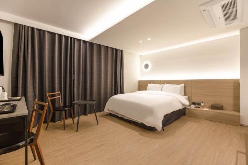 a hotel room with a bed and a table and chairs at H hotel Gasan in Seoul
