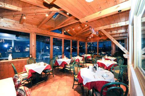 a dining room with tables and chairs in a restaurant at Ski in Ski out Hotel Unterellmau in Saalbach-Hinterglemm