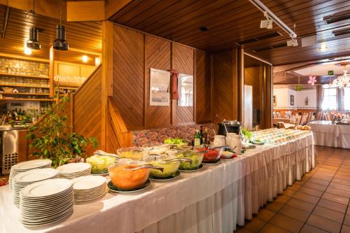 a buffet line with plates and bowls of food at Hotel Krimmlerfälle in Krimml