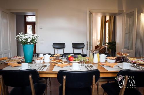 a dining room table with chairs and food on it at Casa Oliva Quero in Quero