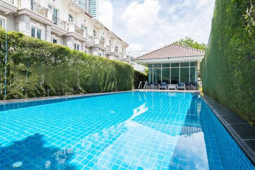 une piscine en face d'un bâtiment dans l'établissement MIQ Asoke808 Pool Villa - Asoke BTS 16 Pax, à Bangkok