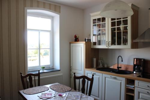 cocina con mesa, fregadero y ventana en Ferienwohnung Ostwind, en Schüller
