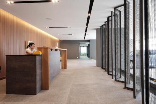 a woman standing at a counter in an office lobby at Maleesa Place Hua Hin in Hua Hin