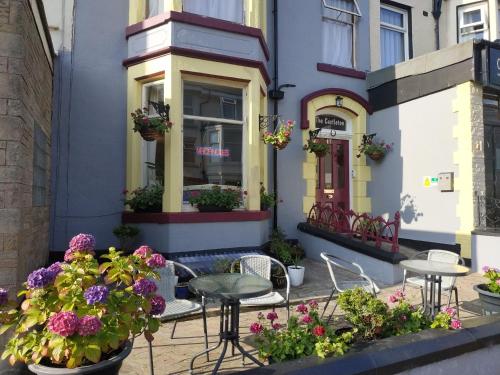 a table and chairs in front of a building with flowers at The Castleton in Blackpool