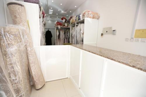 een kleedkamer met witte kasten en een bar bij Al Rayyan Hotel Apartments Muscat in Seeb