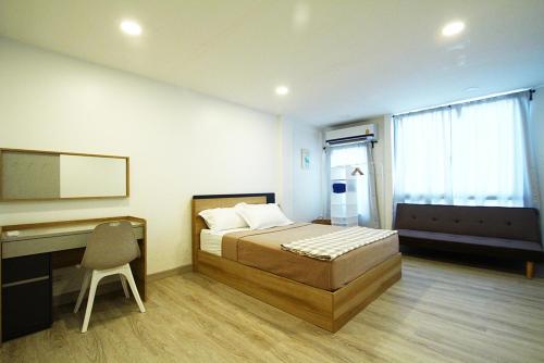 a bedroom with a bed and a desk and a chair at 398 HOSTEL in Bangkok