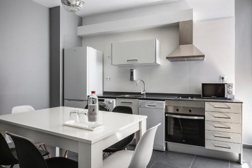a kitchen with a table and chairs and a refrigerator at Mon Suites San Nicolas in Valencia