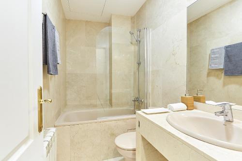 a bathroom with a sink and a toilet and a tub at LEEWAYS APARTMENT XVIII in GRAN VÍA in Madrid
