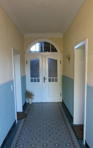 a hallway with a white door and a potted plant at Ferienwohnung Ostwind in Schüller