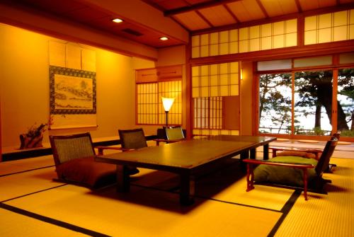 a dining room with a table and chairs at Monjusou Shourotei in Miyazu